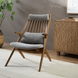 Surya Acworth medium gray accent chair with wood frame, headrest, and lumbar pillow.