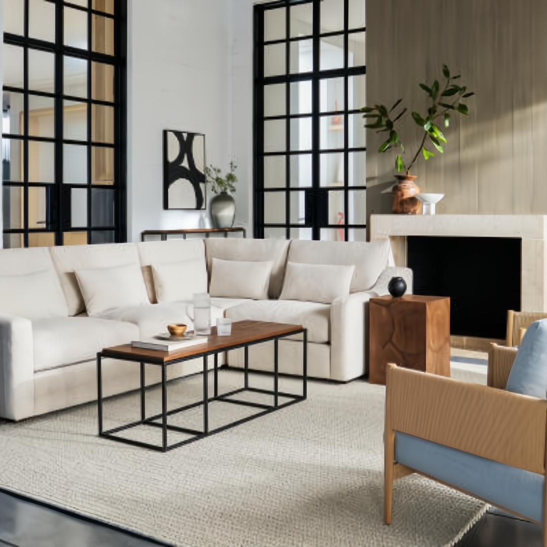Modern living room with a large cream sectional, wood coffee table, and a light blue accent chair.