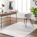 Light beige Surya Floria hand-woven recycled PET rug in a modern home office with a desk and chair.