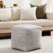 Light gray woven cube pouf made from recycled PET yarn, with a textured finish, in a modern living room.