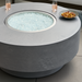 Gray hand-painted aluminum Surya Daniella Fire Table with clear glass beads, drinks, and snacks.