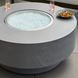 Gray hand-painted aluminum Surya Daniella Fire Table with clear glass beads, drinks, and snacks.