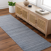 Surya Fresno FNO2300 hand-loomed runner rug in subtle multi-gray recycled PET yarn, on a wood floor.