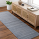 Surya Fresno FNO2300 hand-loomed runner rug in subtle multi-gray recycled PET yarn, on a wood floor.