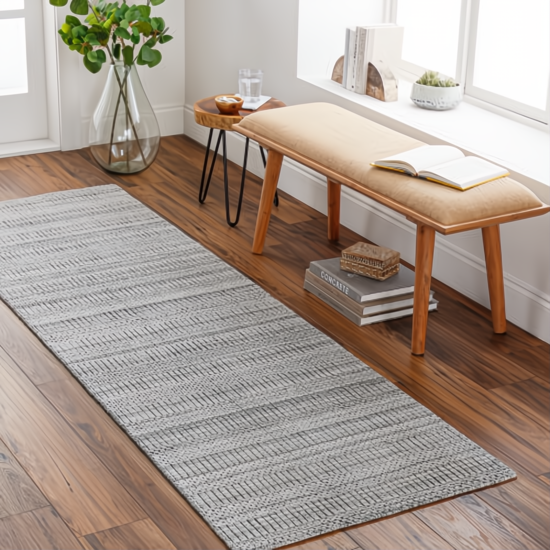 Surya Hickory HCK2303 gray multi-tone hand-loomed recycled PET yarn runner rug on a wood floor.