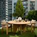 Taupe Surya Palma dining chairs with Sunbrella upholstery and teak wood base around a round outdoor dining table.