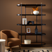 Modern Surya Pearson bookcase with black iron frame, dark brown wood shelves, and brass accents.