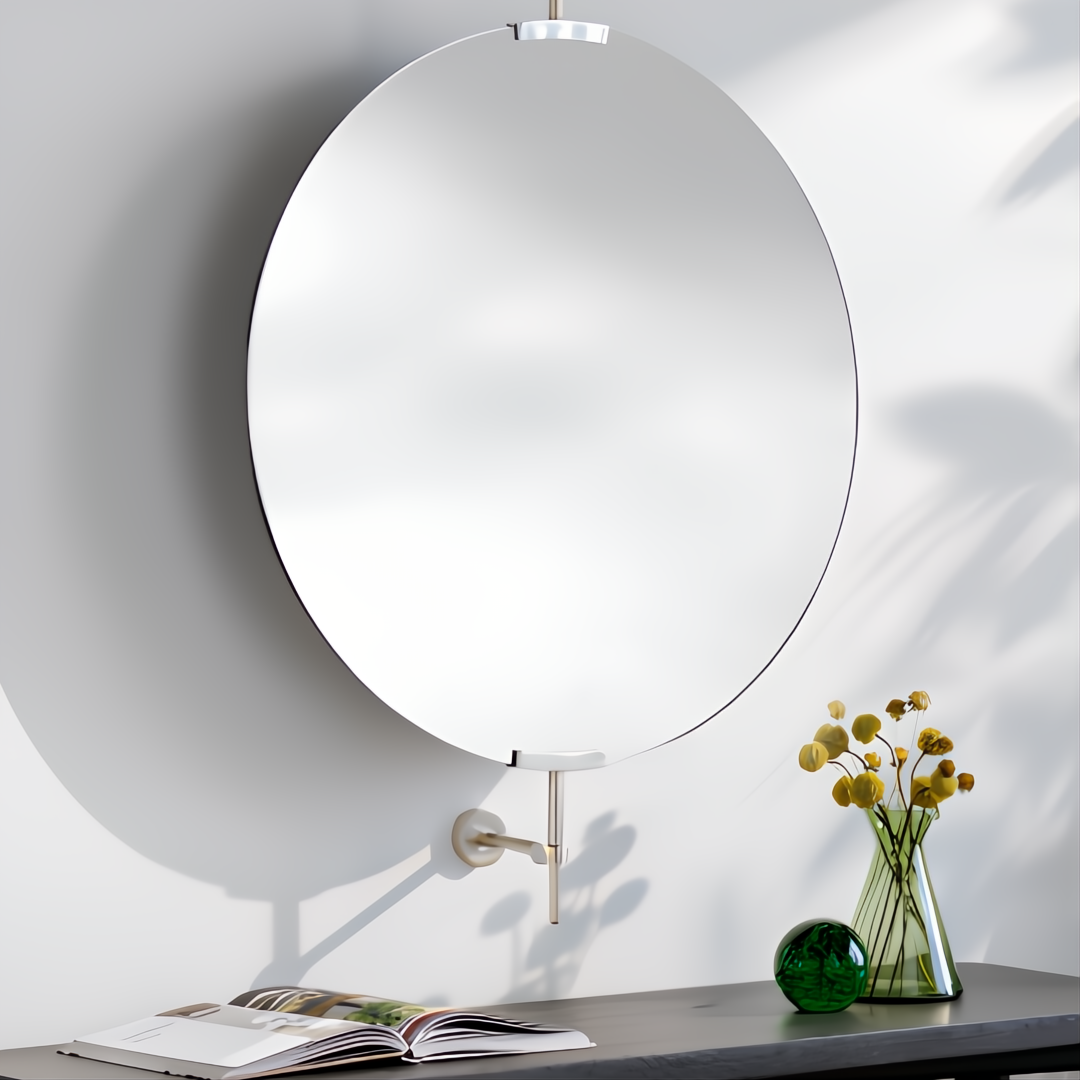Round wall mirror with a slim black frame, gold-toned hardware, and a white wall mount.