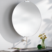 Round wall mirror with a slim black frame, gold-toned hardware, and a white wall mount.