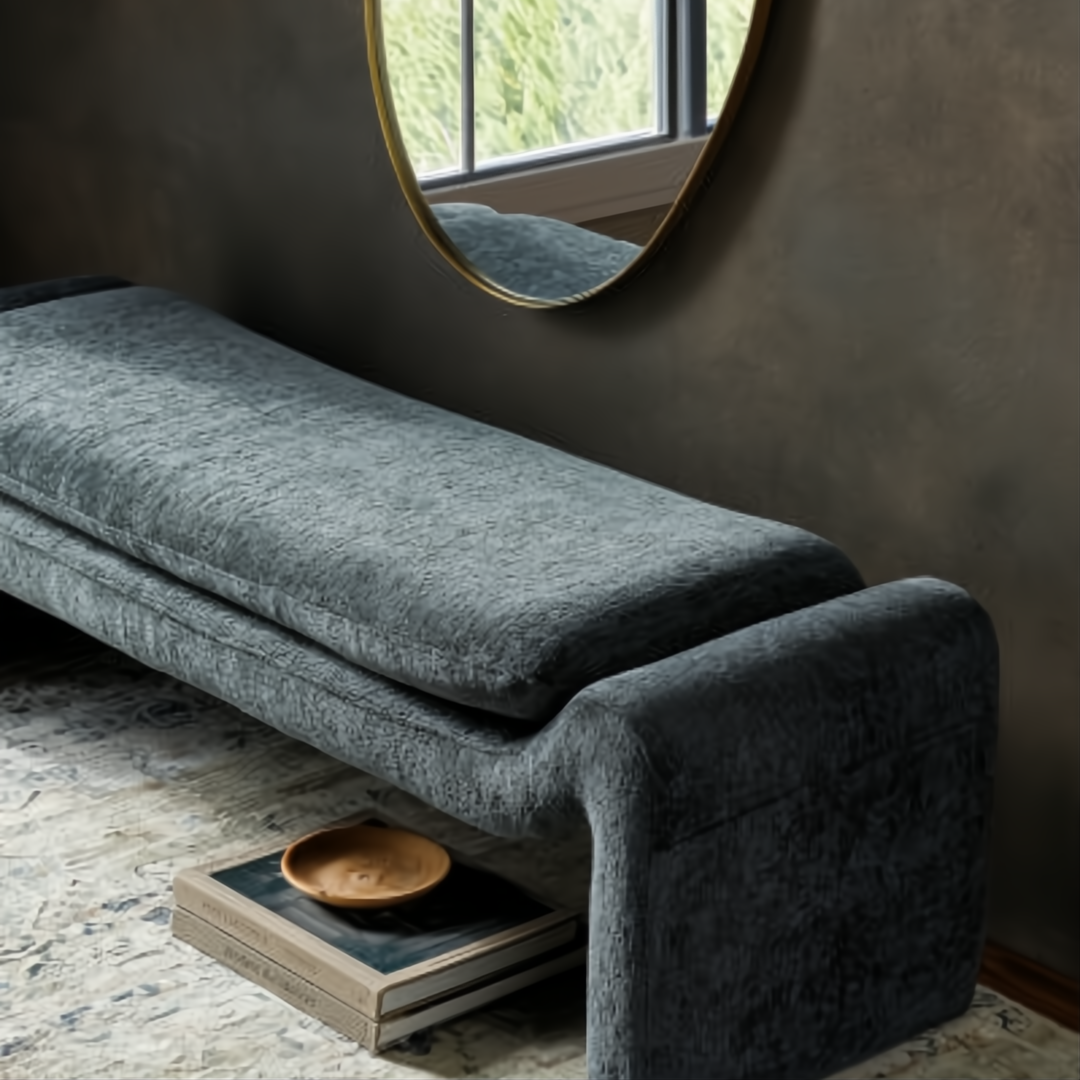Teal upholstered Surya Cascadia bench with a long, low profile and curved ends, on a rug.