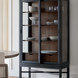 Tall Marin bookcase with black frame, walnut interior, glass doors, and adjustable shelves displaying dishes.