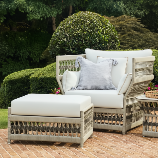 Cream Surya Winder outdoor ottoman with Sunbrella acrylic cushion and aluminum frame, next to a matching chair.
