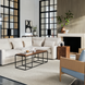 Surya Brax brown lacquered acacia end table with natural wood grain, styled in a modern living room.
