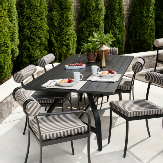 Surya Antibes outdoor dining set with black table and striped Sunbrella chairs on a patio.