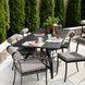 Surya Antibes outdoor dining set with black table and striped Sunbrella chairs on a patio.