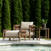 Brown wicker and aluminum Surya Porta outdoor accent chair with Sunbrella cushion by a pool.