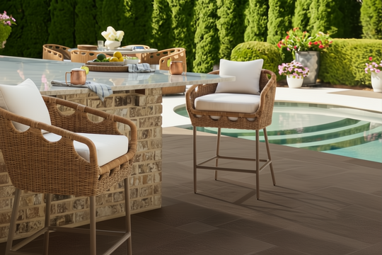 Surya Marvella outdoor bar stools with woven wicker backs, white cushions, and dark brown aluminum bases.