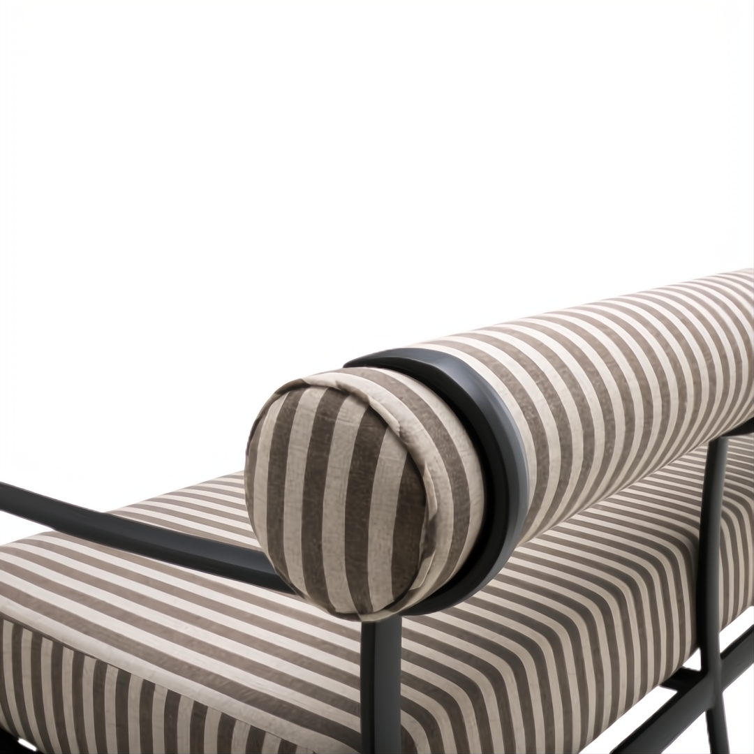 Surya Antibes outdoor sofa with brown and beige striped Sunbrella fabric, black aluminum frame, and bolster armrest.