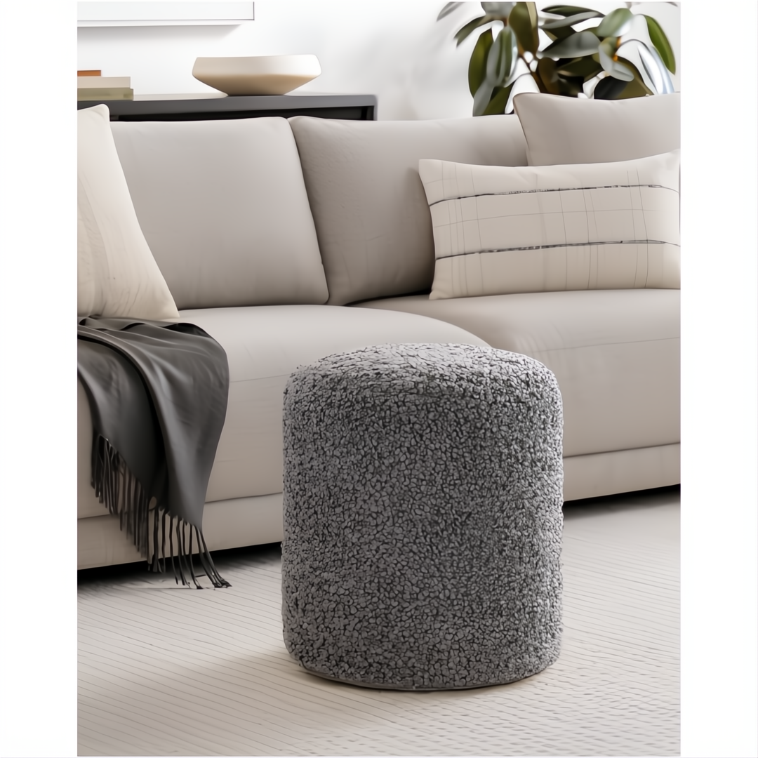 Gray Surya Mohave pouf with a textured, sheepskin-like polyester top, perfect as a footrest or accent piece.