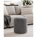 Gray Surya Mohave pouf with a textured, sheepskin-like polyester top, perfect as a footrest or accent piece.
