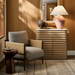 Surya Brielle accent chair with camel polyester upholstery, dark wood frame, and woven sides in a styled room.