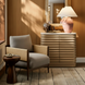 Surya Brielle accent chair with camel polyester upholstery, dark wood frame, and woven sides in a styled room.