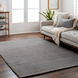Surya Azalea AZA-2316 hand-woven gray recycled PET yarn rug with a minimalist ribbed design in a living room.