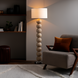 Surya Algarve modern floor lamp with stacked light wood-toned resin spheres, white linen shade, and warm glow.