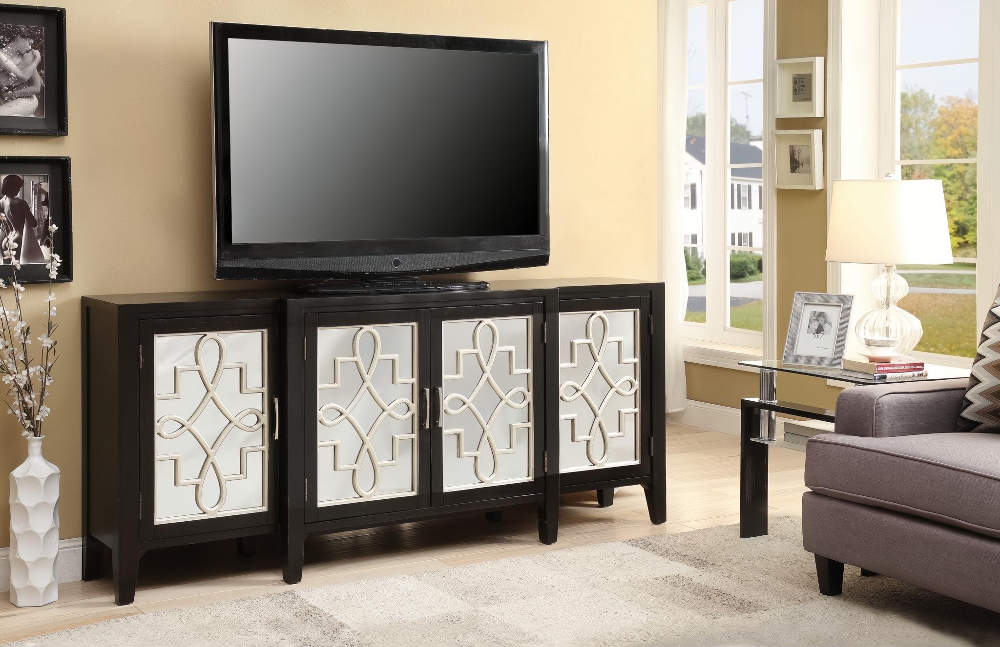 Antique black console table with four doors featuring decorative white geometric overlays, holding a TV.