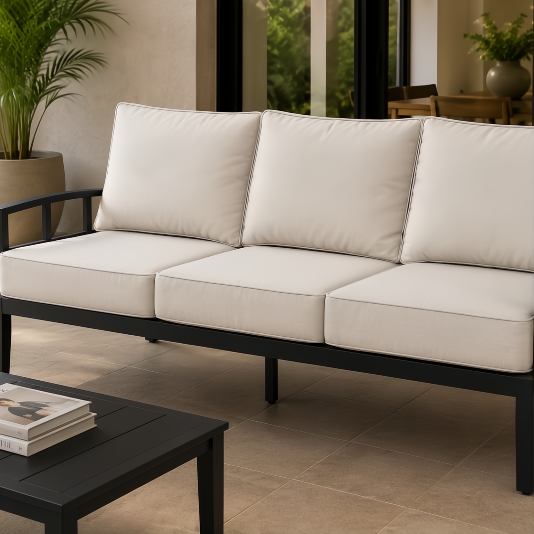 Surya Fairborn 83-inch outdoor sofa with black frame and light beige cushions on a patio.