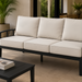 Surya Fairborn 83-inch outdoor sofa with black frame and light beige cushions on a patio.