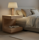 Surya Coburn brown lacquered mango wood end table with open storage beside a bed.
