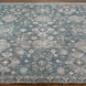 Hand-knotted Surya Almeria rug with a low pile, featuring a distressed teal, gray, and white geometric pattern.