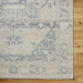 Hand-knotted Surya Cappadocia wool rug with light beige and blue traditional pattern, fringe, on wood floor.