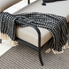 Surya Antibes Loveseat with black aluminum base, beige cushions, and a black and white patterned throw.