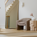 Modern ceramic decorative accent, Surya Acanceh, on a light wood side table next to a beige armchair.