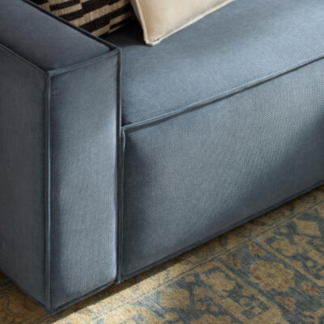 Surya Aira contemporary navy polyester sofa with clean lines and a subtle texture, on a patterned rug.