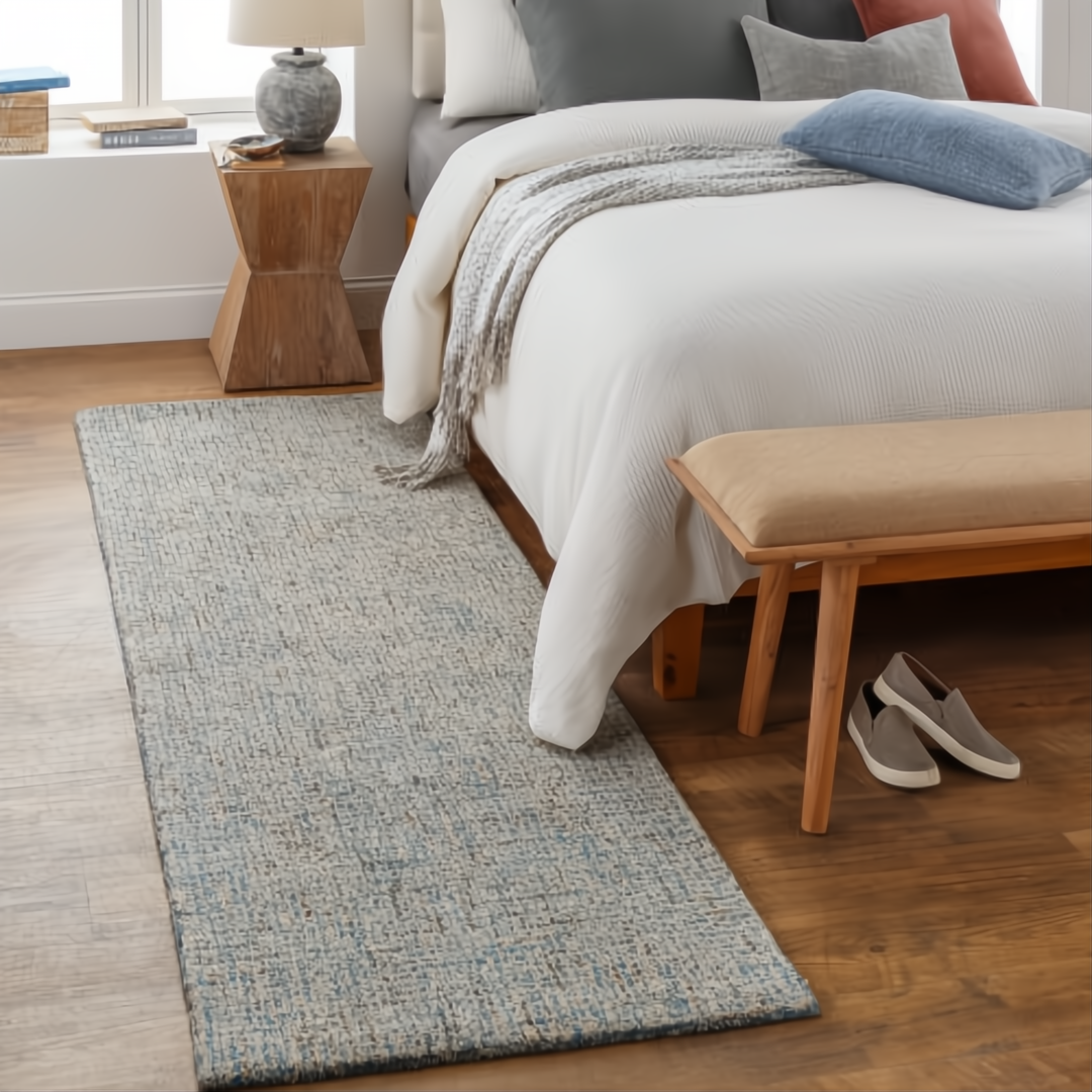 Surya Aiden hand-tufted wool runner rug in light blue and cream, shown in a bedroom.