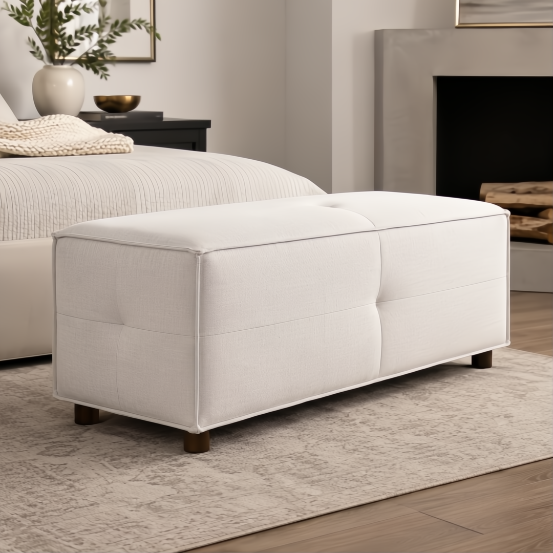 Surya Andra Ottoman, a long rectangular light beige polyester bench with tufted details and wooden legs.