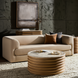 Beige polished marble top Surya Redondo coffee table with ribbed mango wood base in a modern living room.