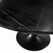 Close-up of a round Surya Anatalia dining table with a black polished marble top and black iron base.