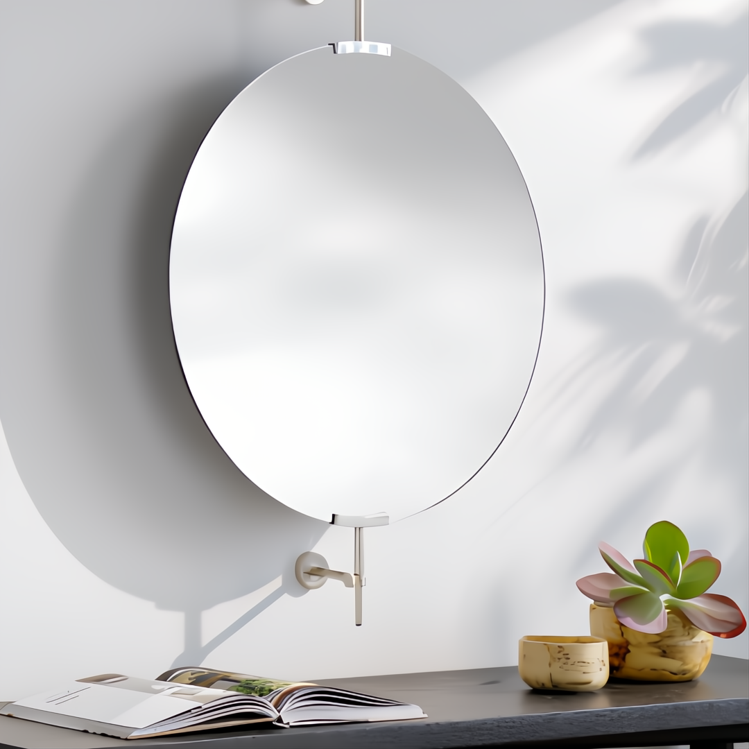 Surya Anastasya AAY-002 round wall mirror with silver hardware, above a dark table with a plant and book.