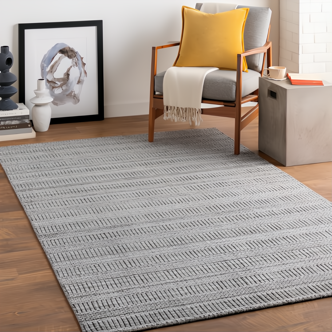 Surya Hickory HCK-2303 gray hand-loomed recycled PET rug with subtle textured stripes in a modern living room.