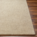 Surya Aiden AEN-1000 medium pile area rug in Tan and Ivory wool on a wood floor.