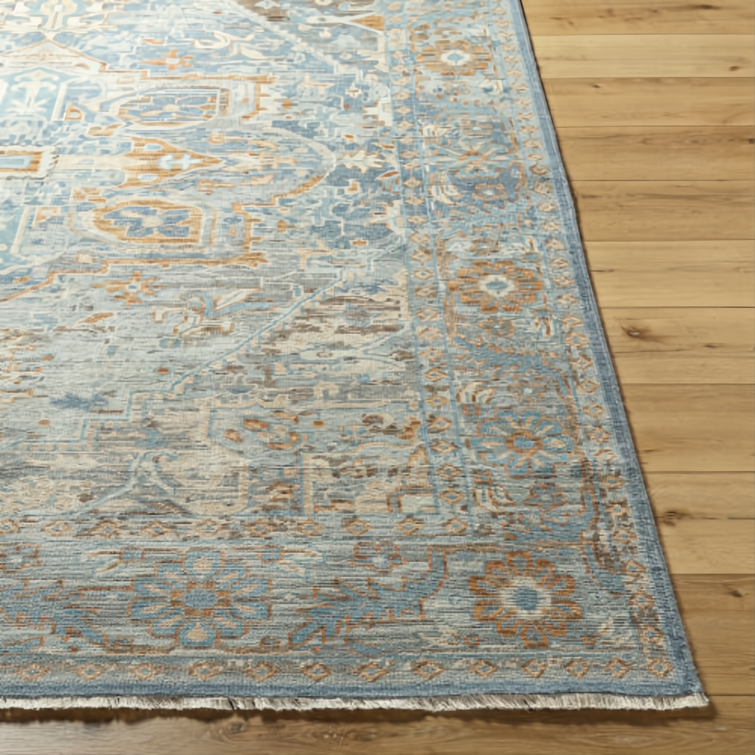 Hand-knotted Surya Cappadocia wool rug in pale blue, gray, taupe, and brown with traditional patterns and fringe.