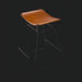 Modern Surya Celerio counter stool with brown lacquered leather seat and gray powder-coated iron base.