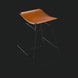 Modern Surya Celerio counter stool with brown lacquered leather seat and gray powder-coated iron base.