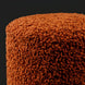 Close-up of a textured, rust-orange Surya Mohave pouf with a cozy, farmhouse cottage aesthetic.