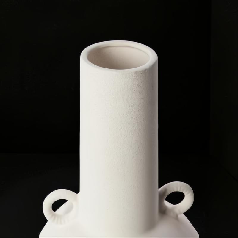Modern white ceramic decorative accent vase with sculptural handles.