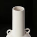Modern white ceramic decorative accent vase with sculptural handles.